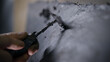 A close-up of a man's hand with a tool. A professional removes the form from the clay with the help of a cycle. The production