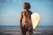 © SERGIO NIEVAS/Westend61 - Shirtless young man with surfboard looking away while standing at beach against sky
