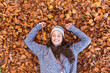 © William Perugini/Westend61 - Smiling female hiker lying down on autumn leaves in Cannock Chase woodland