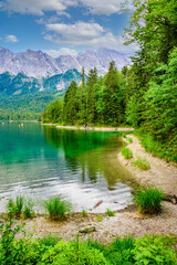 Eibsee lake with Zugspitze mountain in the background. Beautiful landscape scenery with paradise beach and clear blue water in German Alps - Garmisch Partenkirchen, Grainau - Bavaria, Germany, Europe.