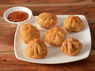 Wall Mural - Veg fried momo with sauce served over a rustic wooden background, selective focus