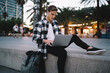 © BullRun - Focused young man browsing laptop on street