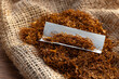 Cigarette paper and pile of tobacco on wooden table