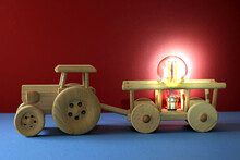 Wooden Toy Tractor And Trailer Carrying A Electric Bulb.