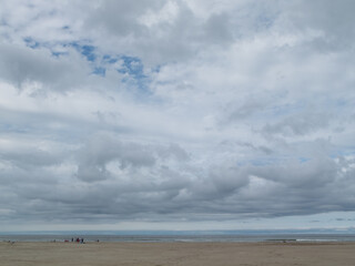 Poster - Beach day cloudy wet sand cold little movement almost no people