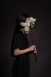 © Milou Dirks - Girl in black with white lilac flower branch in dark painterly studio setting