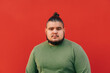 © bodnarphoto - A handsome bearded hispanic overweight guy with a nice hairstyle is standing on a isolated red background and looking at the camera.