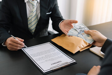 The concept of anti-bribery and corruption. Businessmen refuse and do not receive money banknote offers from businessmen to accept the contract terms of the investment agreement