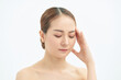 © makistock - Portrait of beautiful young Asian woman with bare shoulders touching her temples feeling stress, on white background