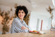 © Drobot Dean - Beautiful happy curly woman smiling while drinking coffee with cake