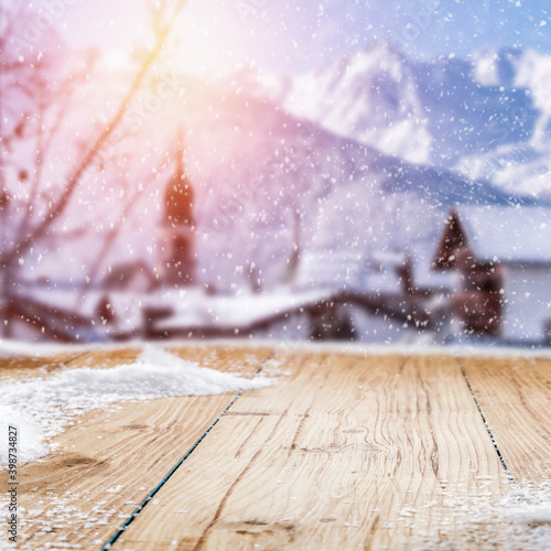 Obraz na plátně Fresh snow on a wooden table with an alpine view of the mountains