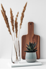 Wall Mural - A mug, a potted houseplant, a clear vase and a wooden cutting board. Eco-friendly materials in the decor of the room, minimalism. Copy space, mock up