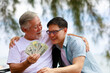 © sutthichai - A man give money to his father.Financial and saving concept.
