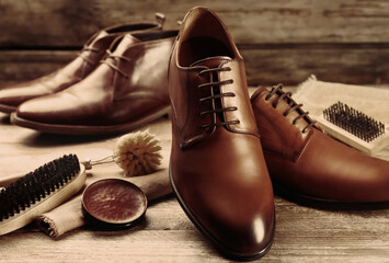 Shoe care accessories and footwear on wooden table, closeup