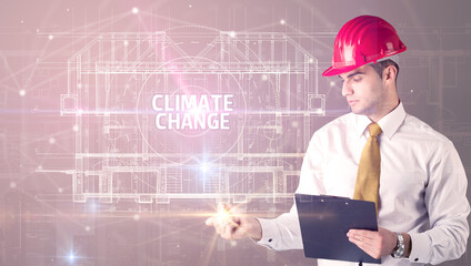 Handsome architect with helmet drawing CLIMATE CHANGE inscription, new technology concept