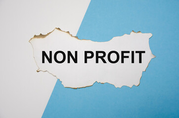 the word non profitwritten on a written on a white sheet of paper which lies on a white and blue background