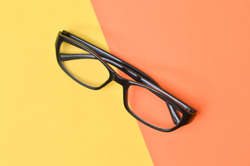 
Top view of eyeglasses isolated on yellow and orange background.