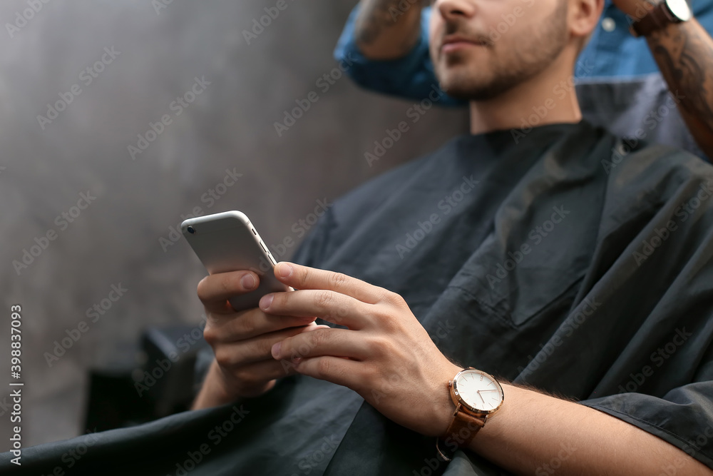 Professional hairdresser working with client in barbershop