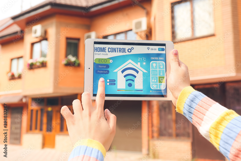 Woman using application of smart home automation on tablet computer