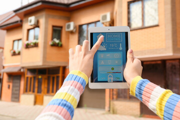 Canvas Print - Woman using application of smart home automation on tablet computer