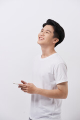 Wall Mural - Handsome smiling man in white t-shirt holding smartphone and typing sms.