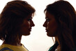 © Svitlana - Silhouetted portrait of two young girls, twin sisters looking at each other, posing together, standing face to face isolated over white background