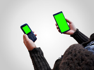 female holding two smart phones mock up in hands with green screen isolated