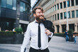 © BullRun - Happy businessman in suit and tie standing in modern district