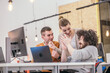 © qunica.com - Happy surprise for the teammates. Coworkers cheering while looking at a computer, screen at the office. Positive vibe at the startup modern office.