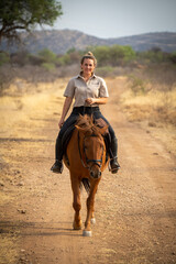 Sticker - Blonde smiles riding horse on dirt track