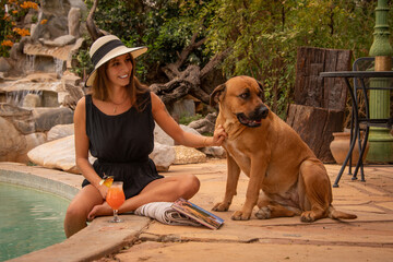 Poster - Brunette in hat stroking dog by pool