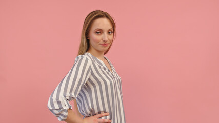 Young confident blond caucasian woman posing over pink background. Copy space. High quality photo