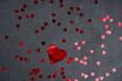 Heart shape confetti on dark concrete background. Love, Valentine invitation concept. Top view, flat lay