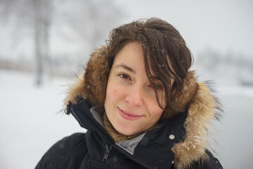 Portrait of a young attractive girl for a walk in the winter forest.