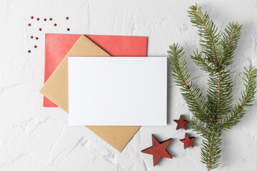 Christmas greeting card mockup with fir branch, blank paper and decor