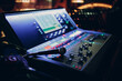 © primipil - Mixing console and microphone, hand equalizing audio sound channels in night club