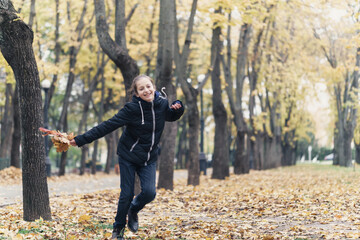 Wall Mural - a girl running through the park and enjoys autumn, beautiful nature with yellow leaves