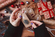 © Yuliya Kashirina - Concept of Christmas items on a table.Women's hands make Christmas advent calendar a wooden background.Christmas Decoration.Top view.