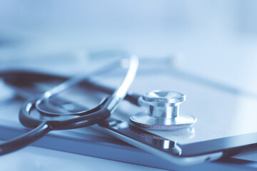 Wall Mural - Medical equipment: blue stethoscope and tablet on white background. Medical equipment