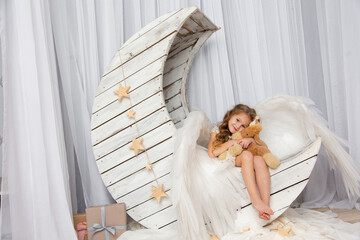 Christmas shooting of a cute little girl in the studio with wings