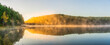 Sunrise panorama at the foggy lake in autumn