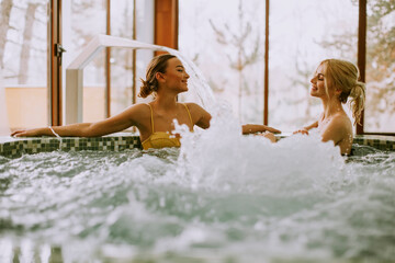 Wall Mural - Young women relaxing in the whirlpool bathtub at the poolside