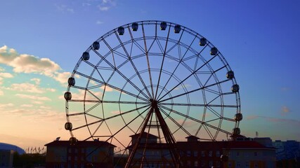 Wall Mural - Ferris wheel against a blue sky.