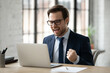 Close up overjoyed businessman wearing glasses excited by good news reading in email or message, happy employee looking at laptop screen, showing yes gesture, received promotion, business achievement