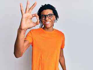 Wall Mural - Young african american man wearing casual clothes and glasses smiling positive doing ok sign with hand and fingers. successful expression.