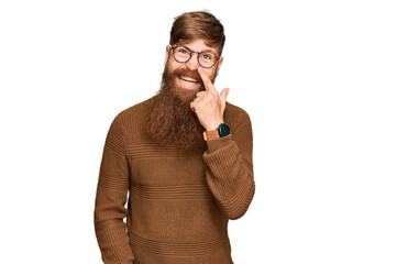 Canvas Print - Young irish redhead man wearing casual clothes and glasses pointing with hand finger to face and nose, smiling cheerful. beauty concept