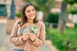 © Krakenimages.com - Young hispanic woman smiling happy holding australian dollars at the city.