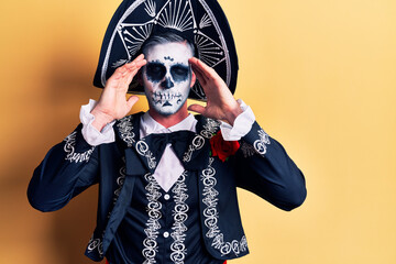 Poster - Young man wearing mexican day of the dead costume over yellow suffering from headache desperate and stressed because pain and migraine. hands on head.