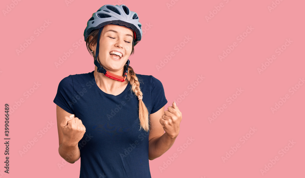 Beautiful caucasian woman wearing bike helmet very happy and excited doing winner gesture with arms raised, smiling and screaming for success. celebration concept. - obrazy, fototapety, plakaty 