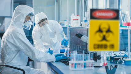 Wall Mural - medical laboratory team of microbiology scientists wearing sterile coveralls, face shields and masks